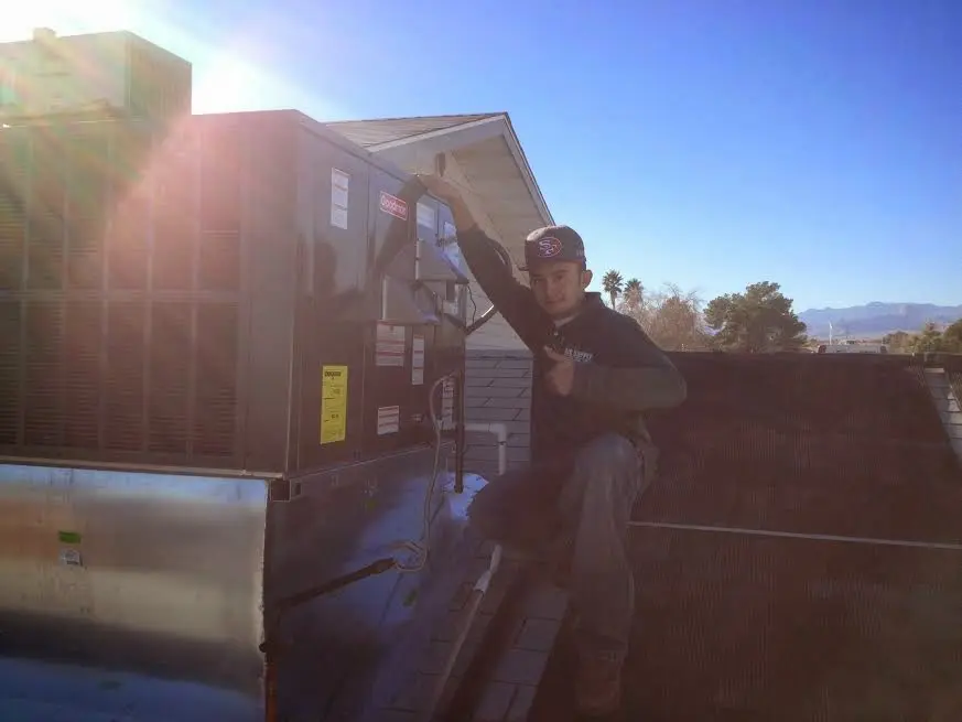 HVAC technician performing Boiler Repair on a rooftop unit in Merrifield